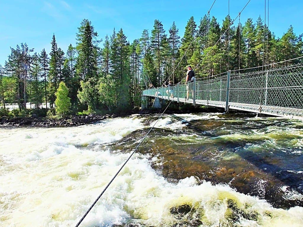 Schwingende Hängebrücke über den beeindruckenden Stromschnellen Mårdsele Forsen