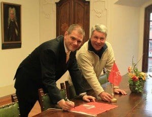 Dr. Alexander Badrow signiert die Stadtflagge für die CMA CGM BAUDELAIRE mit Kapitän Udo Wülms